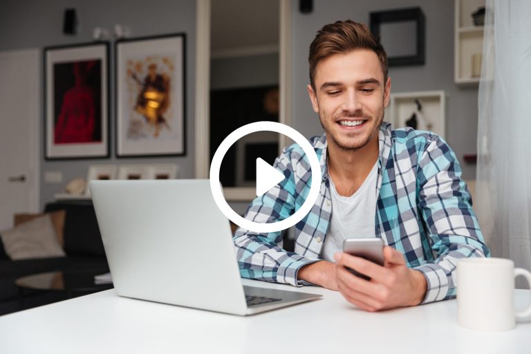 image-of-young-cheerful-man-dressed-in-shirt-in-a-cage-print-sitting-in-home-and-using-SBI-302891216-scaled