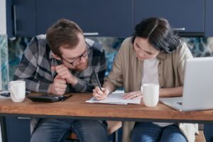 An Australian couple reviewing their personal insurance and household financial documents together at home.