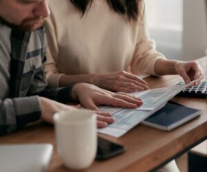 Couple reviewing a superannuation statement together at a wooden table in a bright home setting.